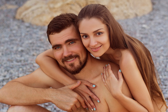 nude couple on the beach hug