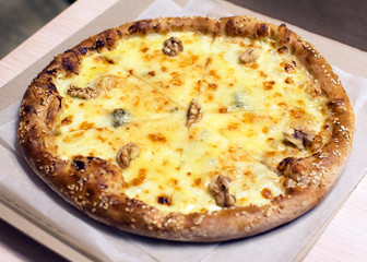 Delicious thin-crust pizza stuffed with different types of cheese and walnut. Original vegetarian pizza delivery. Dishes without meat.