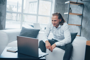 Businessman sitting in front of the laptop and smiling