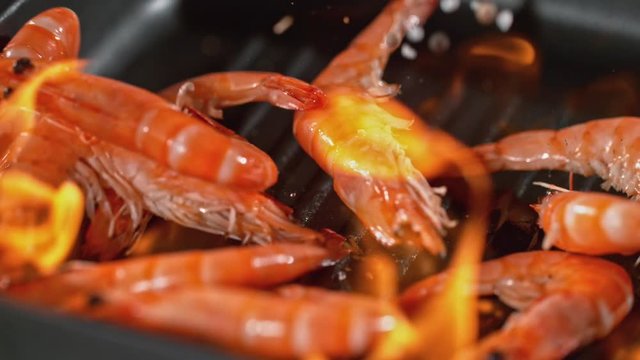 Super slowmotion footage of throwing fresh prawns and seasoning on ignited pan, 1000fps 4k