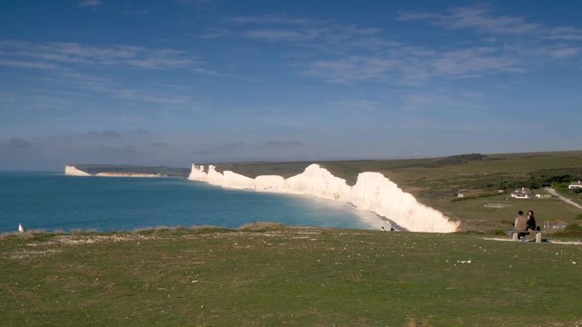 The Seven Sisters cliffs and The South Downs, England. A view over the Birling Gap towards the white chalky cliffs on the south coast of England known as The Seven Sisters on a bright autumnal day.