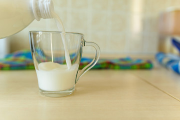 pouring milk from a bottle into a glass beaker. concept breakfast morning energy health