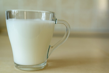 a glass cup of milk on the table in the morning. healthy breakfast concept