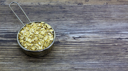 oatmeal or hercules flake close-up on a plate on wooden background. Healthy diet. Oatmeal porridge.