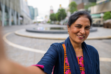 Personal point view of mature Indian woman taking selfie