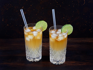 Dark 'n' stormy, a cocktail made using dark rum, ginger ale or beer, served in a highball glass filled with ice and garnished with a slice of lime