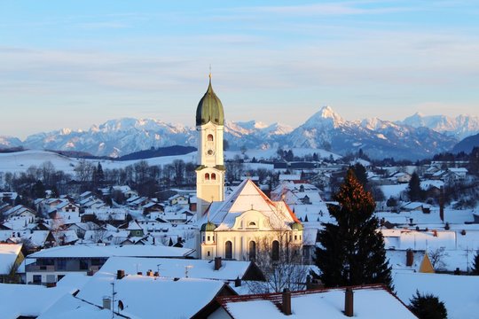 Blick auf Nesselwang im Winter mit Kirchturm, Berge im Hintergrund, Allgäu, Bayern