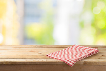 Empty wooden table with table cloth over abstract bokeh background.