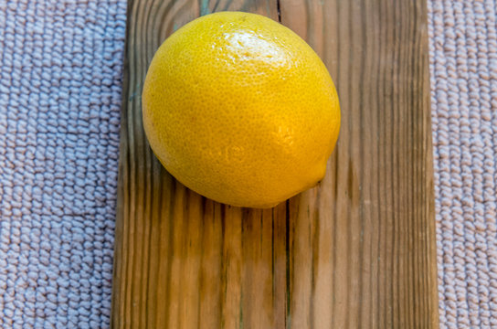 One lemon on wooden palte