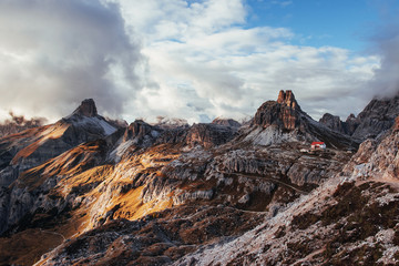 Hill of the dolomite mountains near the Auronzo di Cadore with little buildings near the edge