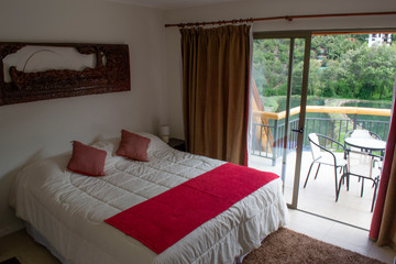 beds in a hotel room. white feather blankets. red curtains. two beds. one double bed. view from the window to the mountains