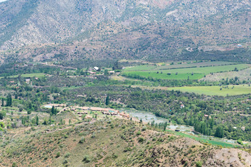 Fototapeta na wymiar view of the valley between the mountains. view from above. to a residential valley. around the chilean mountains. below the village and ponds