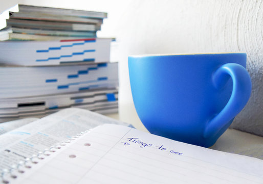 Travel plans in the making with a cup of coffee, books and paper to write down things to see