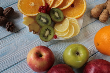 Fruit is on the plate , kiwi, oranges, lemon, pomegranate.