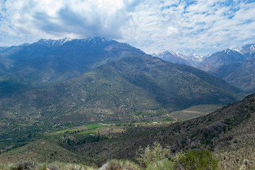view of the valley between the mountains. view from above. to a residential valley. around the chilean mountains. below the village and ponds