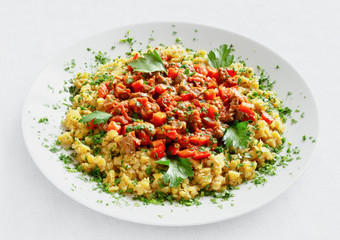 chicken offals stewed with carrot, tomato, onion, and bell pepper served  with lentils and decorated with parsley