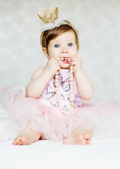 Obraz na płótnie Canvas Charming blue-eyed baby girl in a dress