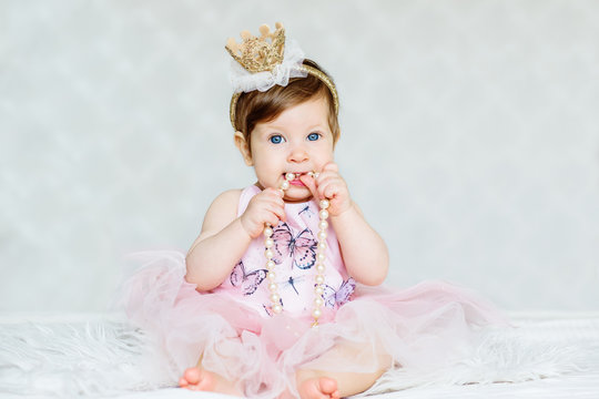 Charming blue-eyed baby girl in a dress