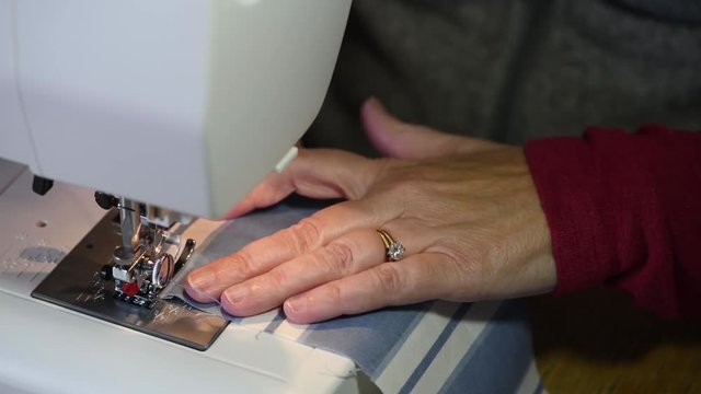 Macro view of a woman sewing with a machine with a shallow depth of field and copy space