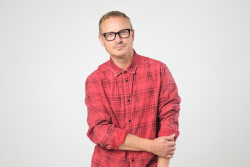 Confident mature man in glasses wearing red shirt looking at camera