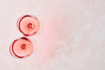 Summer drink. Glass of rose wine on pink background with copy space for text. Top view.