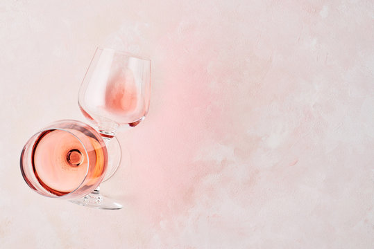 Summer drink. Glass of rose wine on pink background with copy space for text. Top view. Horizontal.