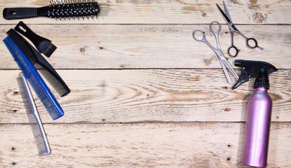 scissors for the hairdresser, comb and brush, the sprayer for hair lie on a wooden board