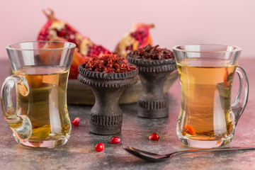 Different varieties of Shisha Smoking hookah. Black annealed ceramic bowl for hookah in the background of tea cups and the open pomegranate.