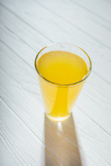 Candid image of one glass of yellow juice