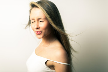 Fototapeta premium Beautiful blond girl posing for photo at home studio on the white wall