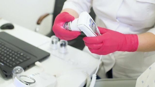doctor dermatologist diagnoses hair structure using a special tool-a trichoscope. Trichology, trichogram