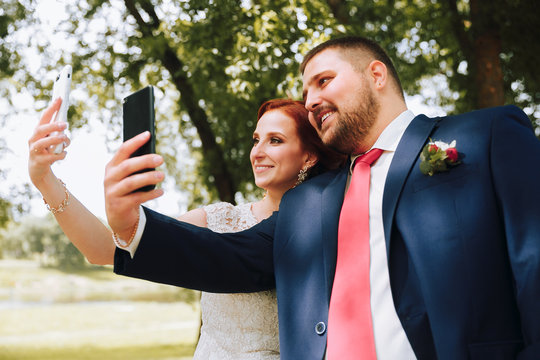 Husband and wife take pictures on the phone.Wedding photo on the phone.Happy couple