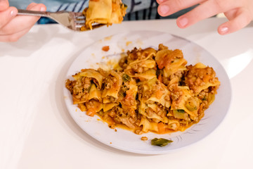 Closeup of Italian lasagna bolognese with cheese crust, homemade on plate, isolated white table background