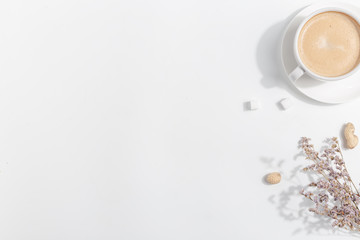 A cup of coffee with milk on a light background. Top view. Copy space.