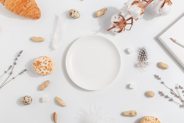 White plate on a light background. Composition with lavender, cotton and nuts.