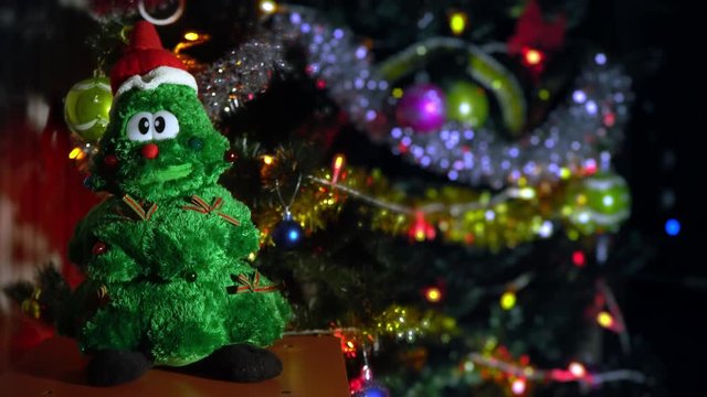 Christmas tree toy sings near a large Christmas tree. New Year and Christmas songs. Family celebration. Present. Making wishes Christmas miracles.