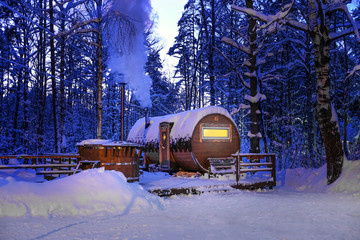 round wooden bath in the winter snowy forest at night