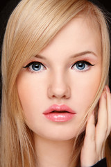 Obraz premium Close-up portrait of young blond girl with winged eye make-up and lip gloss