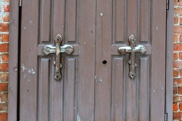 Old wooden doors with orthodox crosses at the entrance to the chapel as background. 