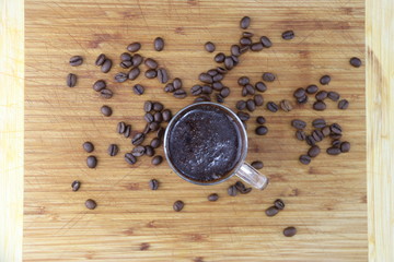 Tasse et grains de café sur une planche en bois