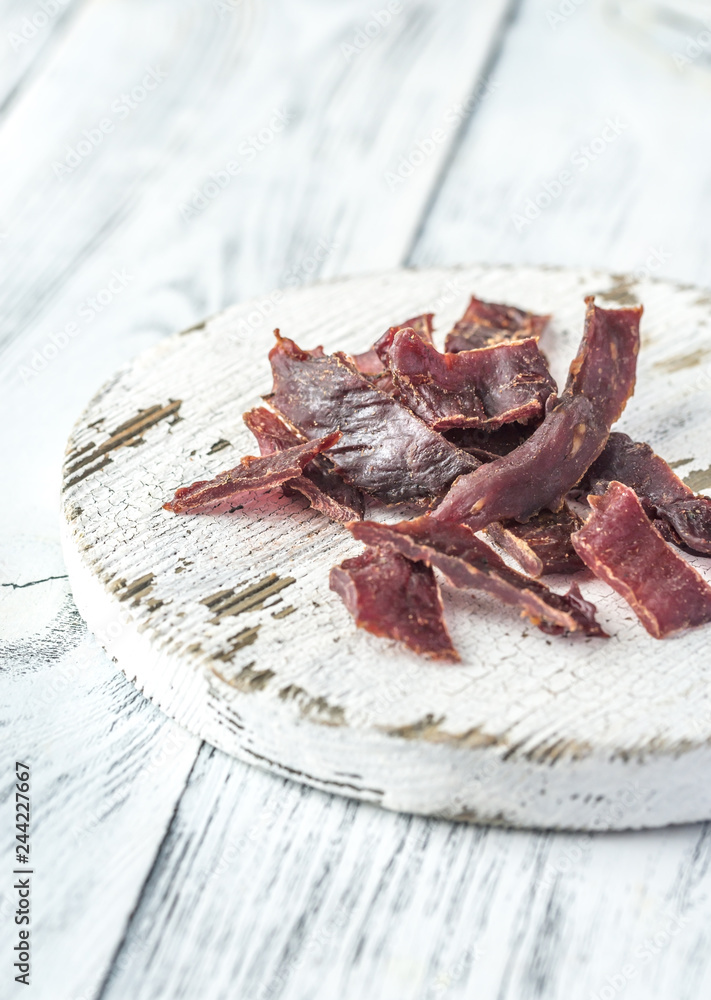 Sticker beef jerky on the white wooden board