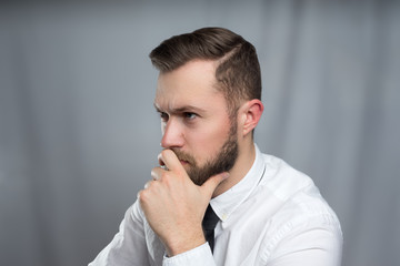 Stressed young bearded businessman sitting in office