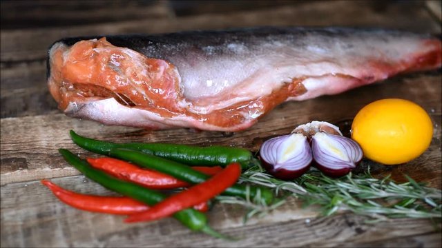 Fresh raw red fish with vegetables on the kitchen table
