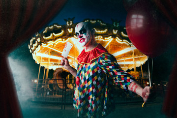 Fototapeta na wymiar Scary bloody clown with baseball bat and balloon
