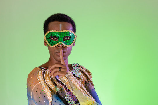 Hands and gesture, silence, quiet. Face of brazilian man wearing costume. Bright background. Party concept, celebration and festival.