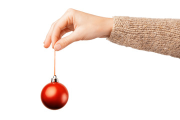 Christmas concept with hand and red ball - christmas tree toy. Red round christmas ball in female hand isolated on white background. Alpha.