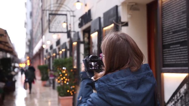 Woman Takes Pictures in street in European City. Travel Europe