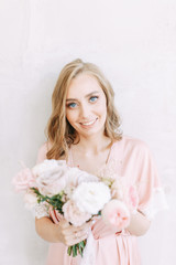 Bright morning bride in a dress on the bed. Photo shoot in bright interior Studio in European style.