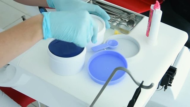 The dentist makes a cast of teeth for prosthetics from a special plastic mass of white and blue. orthopedic dentistry