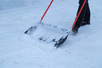 Clearing snow with a shovel in the winter on the street 